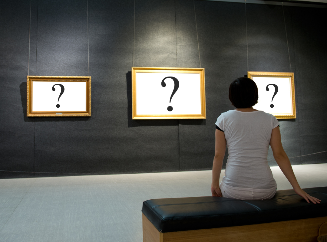 Person wondering while looking at  pictures on a wall